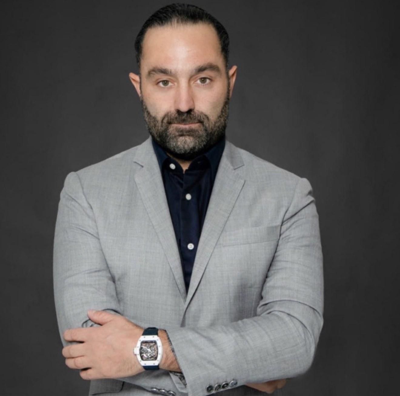 Avery Andon in a grey blazer, arms crossed